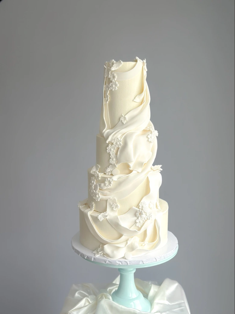 Ivory sculpted wedding cake with cascading draped detail