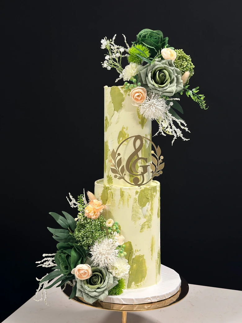 Elegant botanical wedding cake with green roses and gold initials